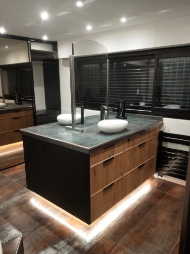 Salle de bain moderne avec un meuble avec plan de travail en pierre et lavabos.